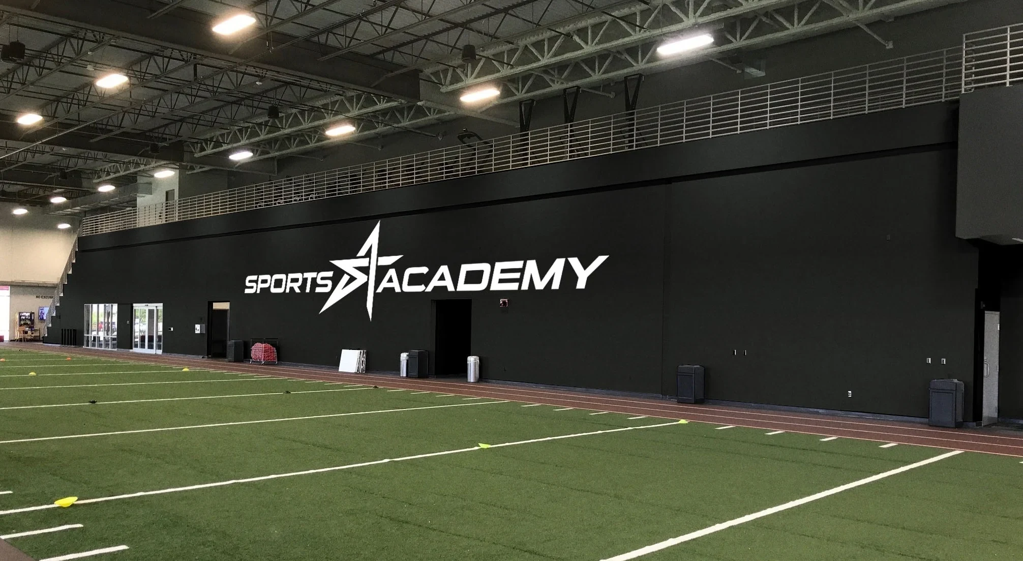 Indoor training field and gym with Sports Academy branding